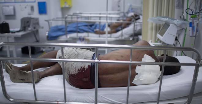 Un hombre que ha sido apuñalado en la espalda descansa en la sala de emergencias de un hospital en Ciudade de Deus, Rio de Janeiro /AFP (MAURO PIMENTEL)