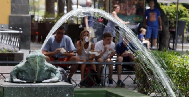 Unos turistas descansan en la plaza de Las Ranas, en Las Palmas, durante la reciente ola de calor registrada en Canarias. EFE/Elvira Urquijo A.