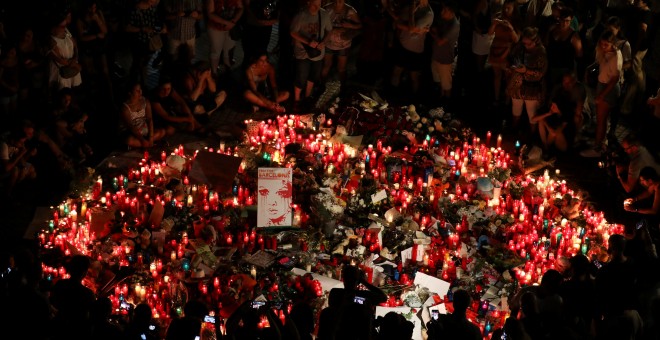 La gente se reúne alrededor de un monumento improvisado un día después de que una furgoneta atropellara a decenas de peatones en Las Ramblas, en Barcelona.- REUTERS / Sergio Pérez