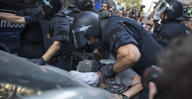 Un policia immobilitza un manifestant xenòfob que ha propinat un cop de puny a un contramanifestant antifeixista. FOTO: Raül Clemente.