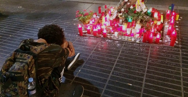 Un jove plora davant un altar improvissat a la Rambla la nit de dissabte. FOTO: Elena Parreño