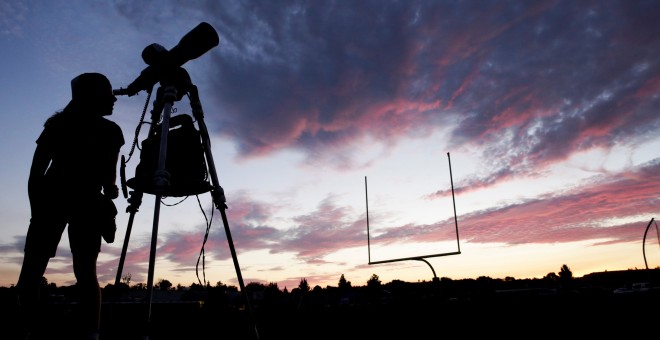 Una mujer mira a través de un telescopio el inicio del eclipse solar total. / REUTERS