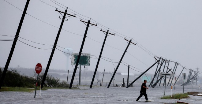 Un hombre cruza una carretera inundada por las lluvias del huracán Harvey. REUTERS/Adrees Latif