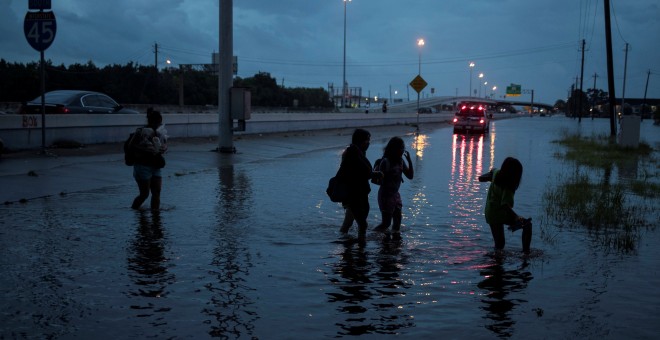 Una familia escapa de la inundación que 'Harevy' ha provocado en Houston, Texas. / REUTERS