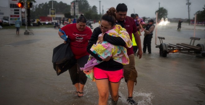 Una familia sale de su casa en Houston. - REUTERS