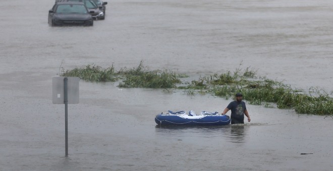 Un residente camina a través de las aguas durante la inundación de la tormenta tropical Harvey en Houston, Texas, EEUU.- REUTERS / Jonathan Bachman