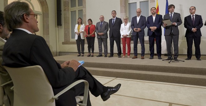 El expresidente de la Generalitat, Artur Mas (i), durante la declaración institucional del presidente del gobierno catalán, Carles Puigdemont (2d), acompañado por los miembros de la mesa tras la firma de la convocatoria del referéndum y la aprobación de l
