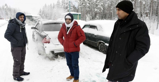 Un refugiado afgano (i) y un paquistaní (d) esperan cerca de la localidad rusa de Kuoloyarvi a poder cruzar la frontera con Finlandia, que junto a Noruega, bloqueó la ruta del Ártico en 2016 - AFP