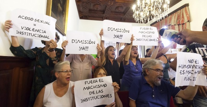 Asistentes al pleno del ayuntamiento de La Laguna muestran carteles en protesta por los comentarios machistas en WhatsApp del concejal del PSOE Zebenzuí González. EFE/Ramón de la Rocha
