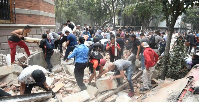 Residente de Ciudad de México recogen la runa de un edificio después del terremoto / AFP