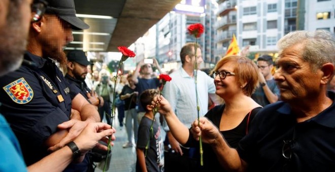 Manifestants a València, solidaris amb Catalunya, lliuren clavells a policies davant la delegació de govern / EFE Kai Foersterling