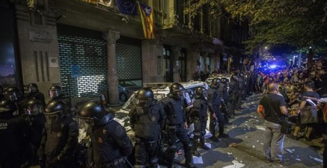 Agentes de los Mossos d'Esquadra custodian las puertas de la sede de la consellería de Economía de la Generalitat en cuyo interior se encontraba un grupo de agentes de la Guardia Civil que realizaban un registro con motivo del 1-O desde las ocho de la ma