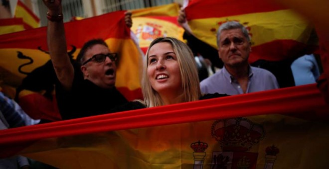 Una mujer con una bandera española en las calles de Barcelona. | REUTERS