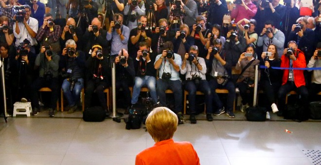 La canciller alemana, Angela Merkel, deposita su voto ante una nube de fotógrafos. REUTERS/Fabrizio Bensch