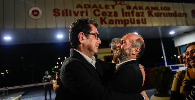 El periodista turco Kadri Gursel (I) abraza al jefe de la delegación de 'Cumhuriyet' en Ankara, Erdem Gul (D), tras ser liberado de la prisión de Silivri el 26 de septiembre del 2017, en Estambul. AFP/ Yasin Akgul