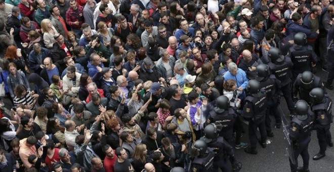 Policía Nacional y Guardia Civil ante los concentrados en el colegio Ramón Llull de Barcelona./ EFE