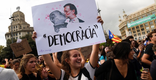 Una joven sostiene una pancarta contra Mariano Rajoy durante la concentración de estudiantes en Barcelona contra la violencia policial durante el referéndum del 1-O. REUTERS/Eloy Alonso