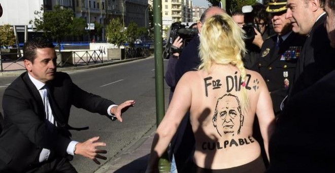 Una activista de Femen protesta contra le 'ley moprdaza' frente al entonces ministro del Interior, Jorge Fernández Díaz, en Madrid en 2015.- AFP