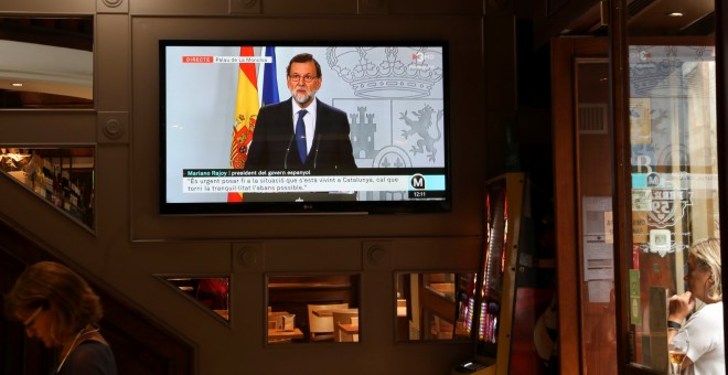 Un monitor de televisión en un bar de Barcelona durante la emisión de la comparecencia del presidente del Gobierno,Mariano Rajoy, tras el Consejo de Ministros extraordinario. REUTERS/Susana Vera