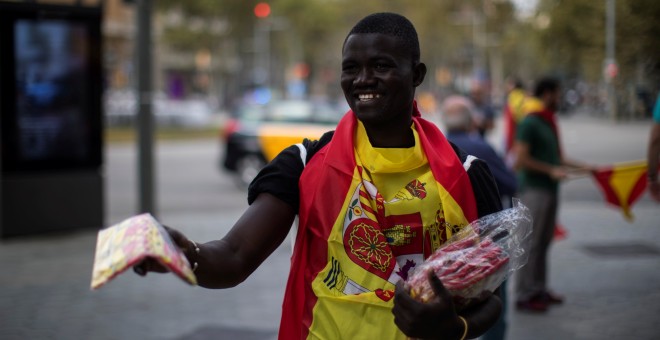 Un vendedor callejero ofrece banderas españolas en Barcelona durante el día de la Fiesta Nacional. REUTERS/Juan Medina