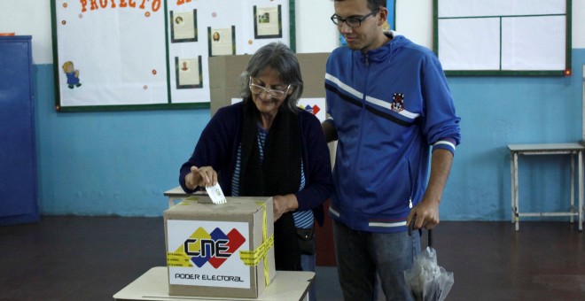 Una mujer vota introduce su voto en las elecciones regionales de Venezuela. REUTERS/Carlos Eduardo Ramirez