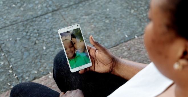Oumo observa una foto de su hijo en su teléfono móvil.- LAURA MARTÍNEZ / WOMEN'S LINK