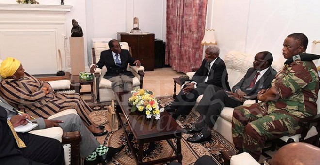 Mugabe (c.), en una reunión en el palacio presidencial con el jefe del Ejército, Constantine Chiwenga (d.).