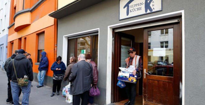 Varias personas se sitúan en la puerta de un banco de alimentos en la ciudad alemana de Dortmund./REUTERS