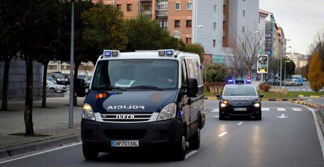 El coche y el furgón de la Policía que conduce a la manada al Palacio de Justica de Navarra. | EFE