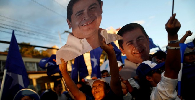 Los partidarios de Hernández sostienen figuras del candidato a la reelección mientras esperan los resultados oficiales de las elecciones presidenciales en Tegucigalpa. / Reuters