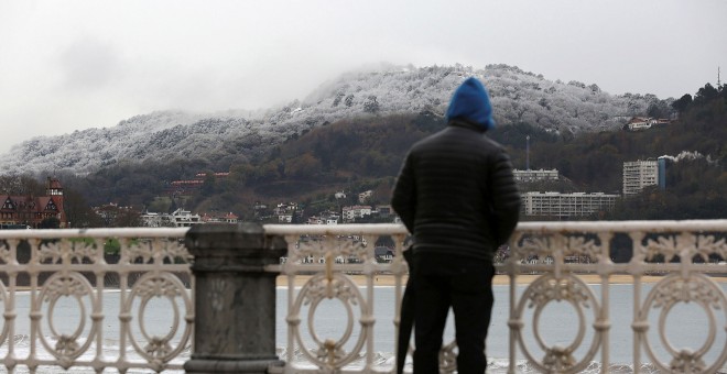 Un hombre observa la nieve caída en San Sebastián. EFE/ Gorka Estrada