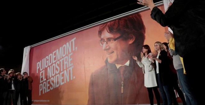 Un cartel con la imagen del candidato a la Generalitat de Catalunya, Carles Puigdemont, durante el acto electoral de inicio de campaña que la formación Junts per Catalunya ha celebrado esta noche en el edificio Imagina de Barcelona, EFE / Susanna Sáez.