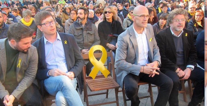 Gabriel Rufián, Carles Mundó, Raül Romeva i Antoni Castellà, en un acte a Vilanova i la Geltrú, deixen una cadira buida amb el llaç grog, per assenyalar l'obligada absència d'Oriol Junqueras / Europa Press