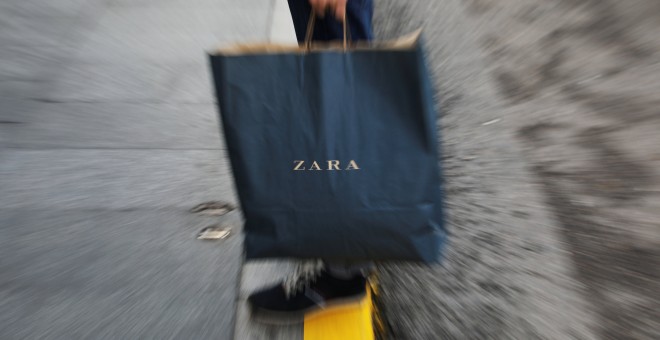 Un hombre con una bolsa de Zara, la principal enseña de Inditex, fuera de una de sus tiendas en el centro de Madrid. REUTERS/Susana Vera
