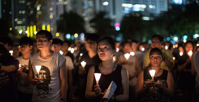 Miles personas sostienen velas mientras participan en una vigilia con motivo del 26 aniversario de la matanza de Tiananmen, en el Victoria Park de Hong Kong, China. EFE