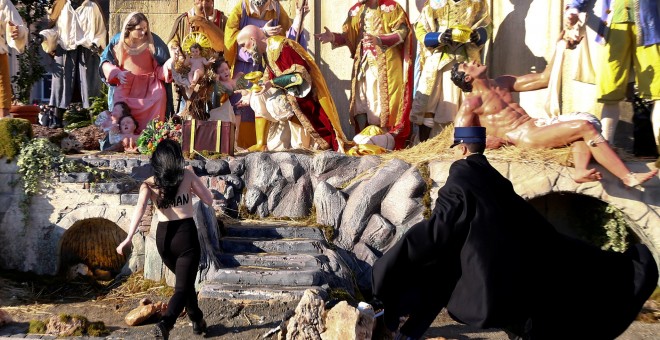 Una activista de Femen intenta llevarse al Niño Jesús del belén del Vaticano. REUTERS/Tony Gentile