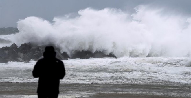 Un hombre observa una ola en el espigón del Kursaal de San Sebastián, durante el paso del temporal de invierno Bruno. - EFE
