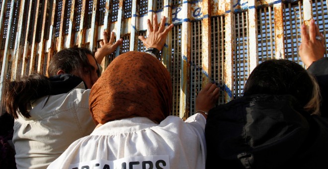 Los 'Dreamers' protestan por la derogación de la ley DACA cerca de la doble valla de acero que separa a EEUU y México en la frontera de Tijuana, México. / Reuters