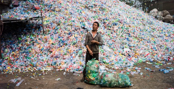Un trabajador recoge botellas de plástico en una de las plantas de reciclaje de China. FRED DUFOUR / AFP