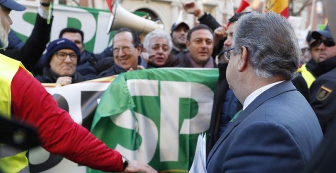 El ministro del Interior, Juan Ignacio Zoido, se dirige a los policías concentrados frente a la Dirección General de la Policía que reclaman la equiparación salarial con otros Cuerpos. | JAVIER LIZÓN (EFE)