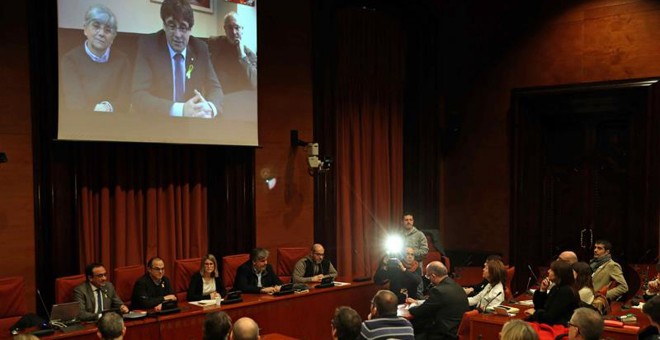 Los diputados electos Carles Puigdemont (c), Clara Pontasí (i) y Lluís Puig (d), participaron telemáticamente desde Bruselas en la reunión celebrada el martes en el Parlament por el grupo parlamentario de Junts per Catalunya. EFE/Toni Albir
