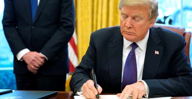 Donald Trump firma una orden presidencial en el Despacho Oval. /REUTERS