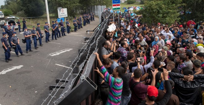 Los refugiados se agolpan ante la frontera húngara esperando para entrar en territorio de la UE, en una imagen de verano de 2015. REUTERS