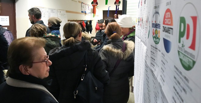 Una mujer observa la lista de partidos en un colegio electoral en Roma. /REUTERS