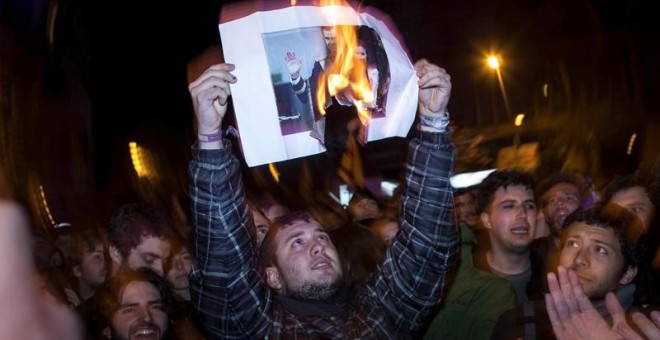 Manifestants cremen una fotografia del rei / EFE