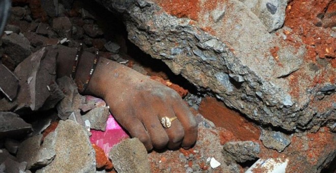 La mano de una mujer entre los escombros del edificio derrumbado./ EFE