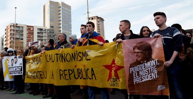 Varias personas sostienen una pancarta durante la concentración que miembros de los Comités de Defensa de la República (CDR) llevan a cabo en los exteriores de la Estación de Sants de Barcelona, donde se ha desplegado un dispositivo de los Mossos d'Esqua