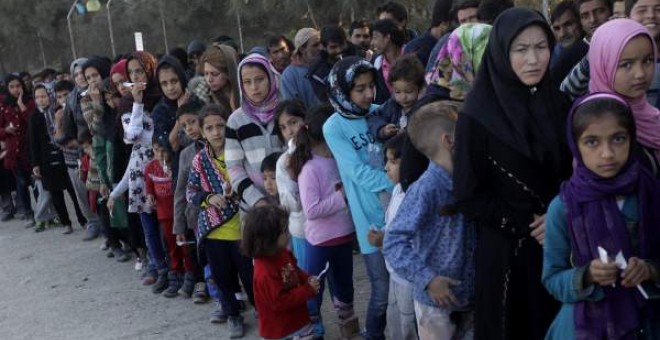 Grupos de refugiados hacen cola para recibir alimentos en el centro de Moria, en la isla griega de Lesbos - EFE