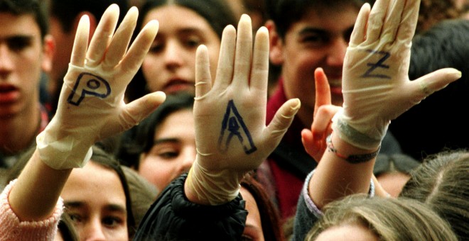 Varias jóvenes levantan sus manos para que se lea escrita la palabra 'Paz' en una concentración contra ETA frente al Ayuntamiento de Sevilla, en febrero  de 1998.. REUTERS/Marcelo del Pozo