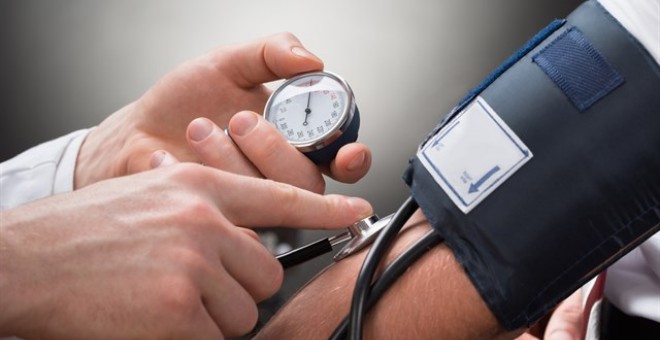 Médico midiendo la presión arterial a un paciente. ISTOCK